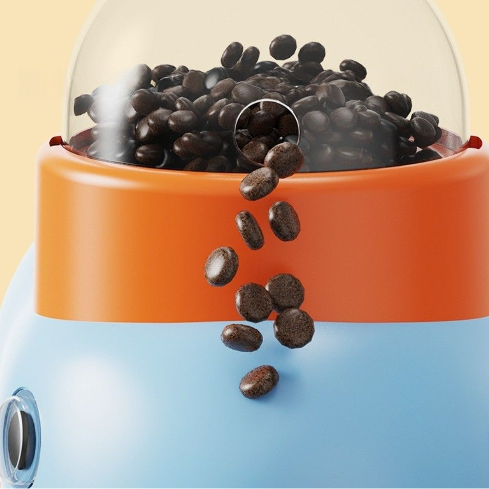 Interactive feeder for pets, featuring a colorful design with coffee beans spilling from the dispenser.