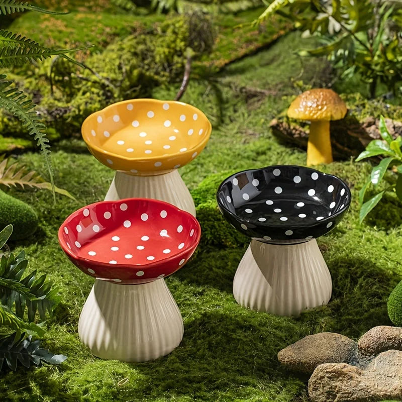 Ceramic cat feeder with mushroom elevated shelf in yellow, red, and black polka dots for comfortable pet feeding.