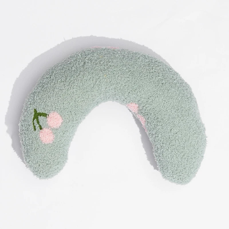Cat resting on small U-shaped pet pillow in soft plush fabric