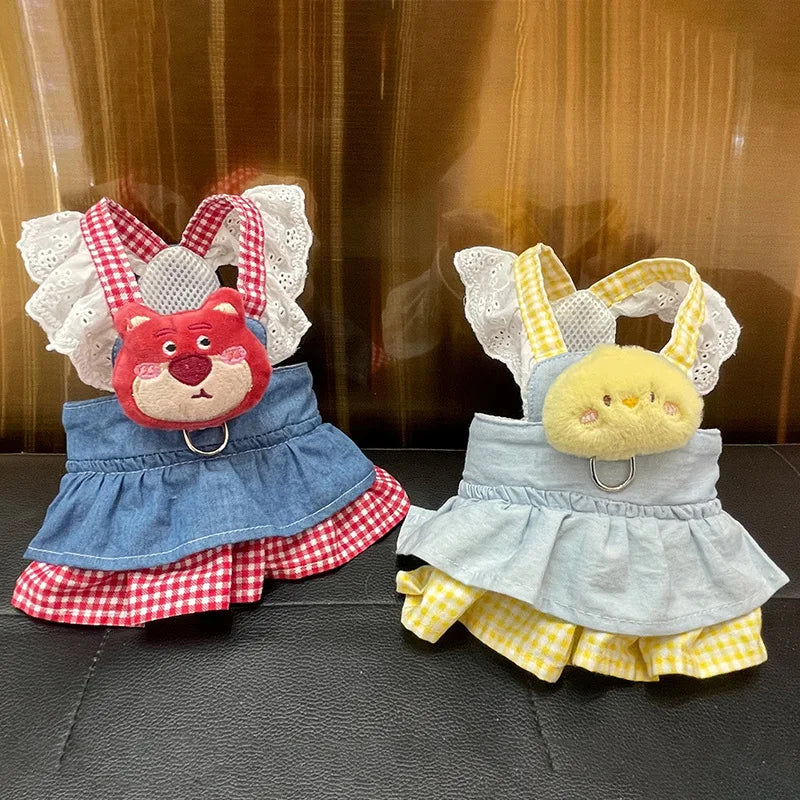 Small dog wearing pink doll-style harness with denim skirt and matching leash
