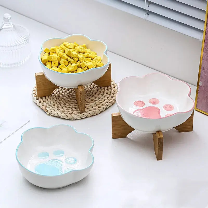 Cat paw-shaped ceramic pet bowl with bamboo stand, perfect for cats and dogs.