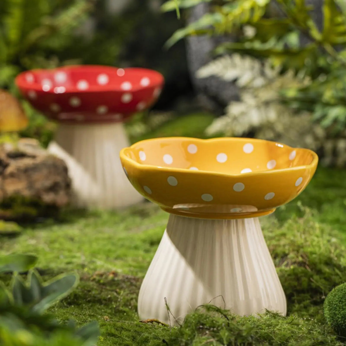 Ceramic cat feeder with mushroom elevated shelf in yellow and red polka dot design.