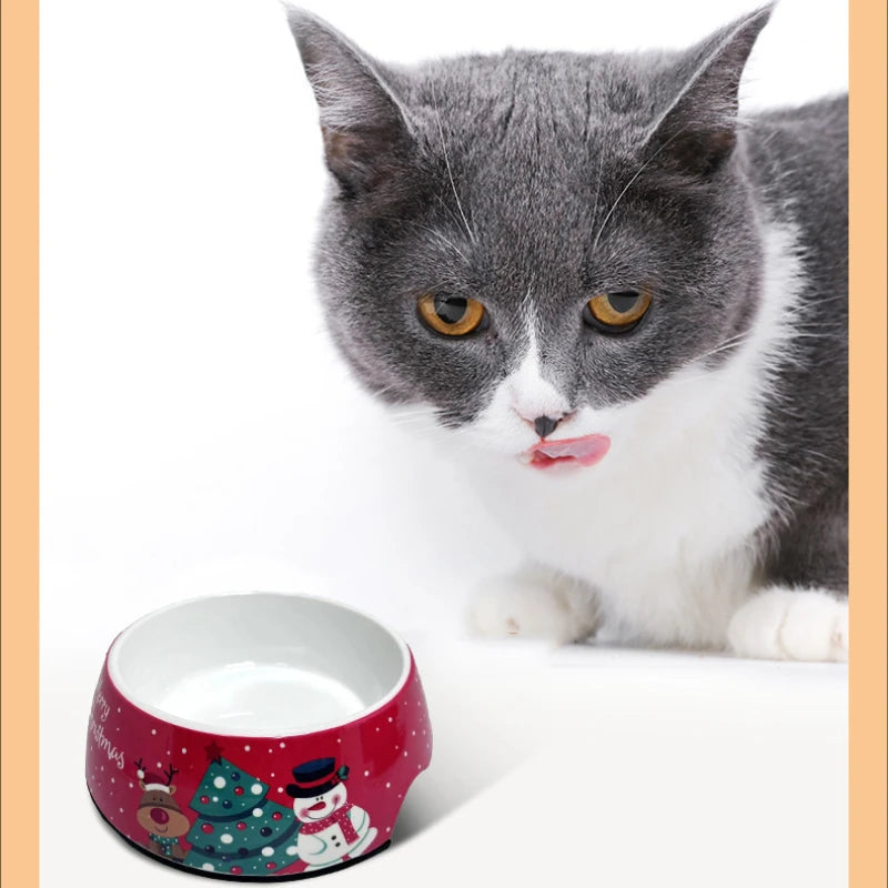 Christmas stainless steel pet bowl next to a cute cat, showcasing festive design and practical durability.