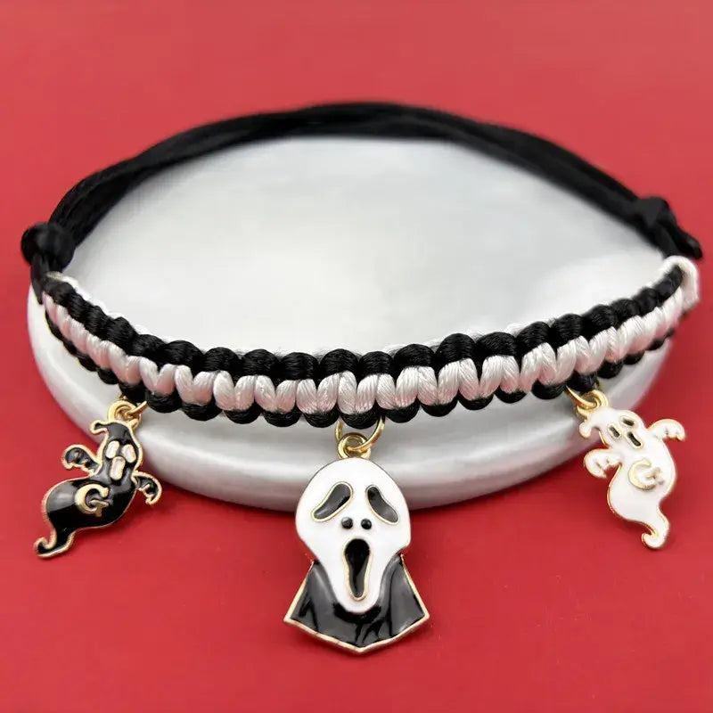 Cat wearing a Halloween breakaway collar with a small pumpkin pendant and festive woven design.