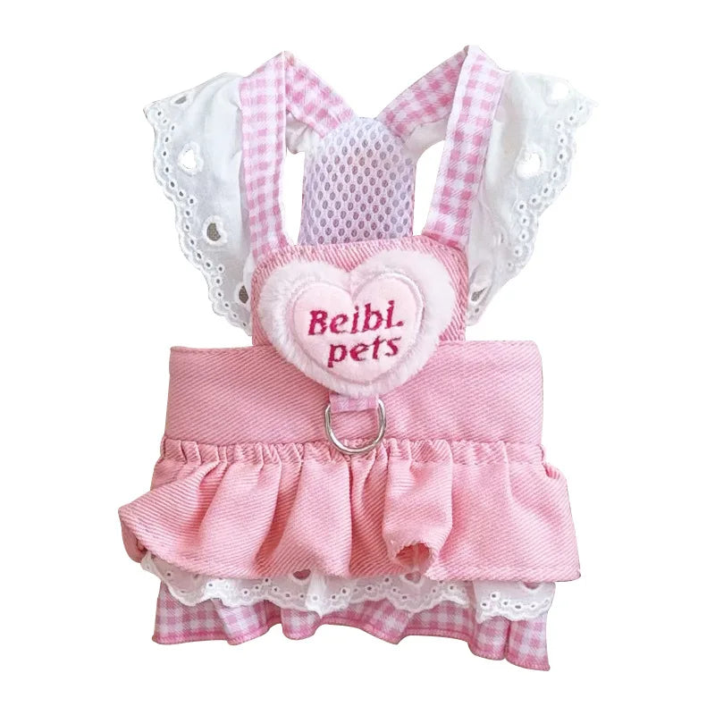 Small dog wearing pink doll-style harness with denim skirt and matching leash